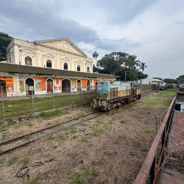 Patio de una estación con una locomotora antigua frente al edificio