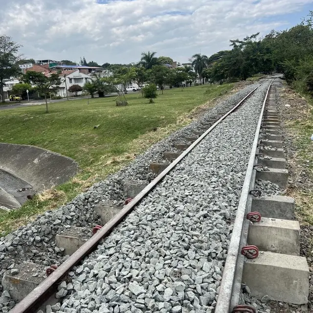 Vía con balasto y traviesas nuevas en una zona urbana